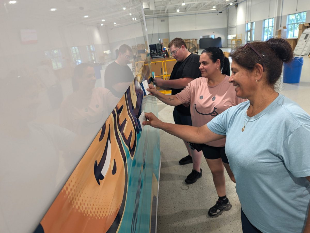 Crew applying a printed wrap panel to a vehicle