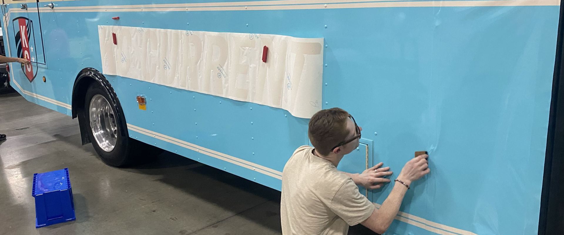 Installer smoothing vinyl onto a trailer panel